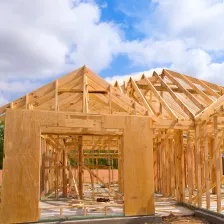 Exterior view of a modern two-story home under construction in Los Angeles with exposed wooden roof framing and wall structures, showcasing a new residential build by Best Construction LA.